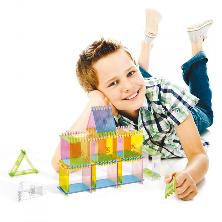 Set constructie Quercetti Playform, 60 piese – copil lângă o construcție din plăcuțe