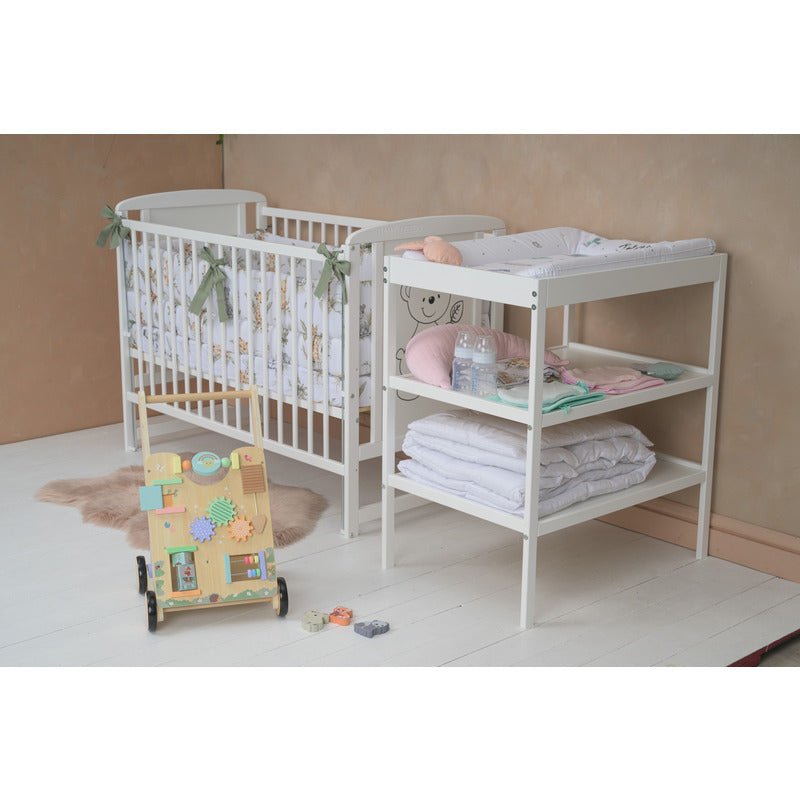 Pătuț BabyNeeds Timmi alb – pătuț amenajat cu textile, lângă o masă de înfășat