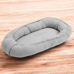 Baby nest New Baby Muselina 80x50 cm, Gri deschis – vedere pe fundal din lemn