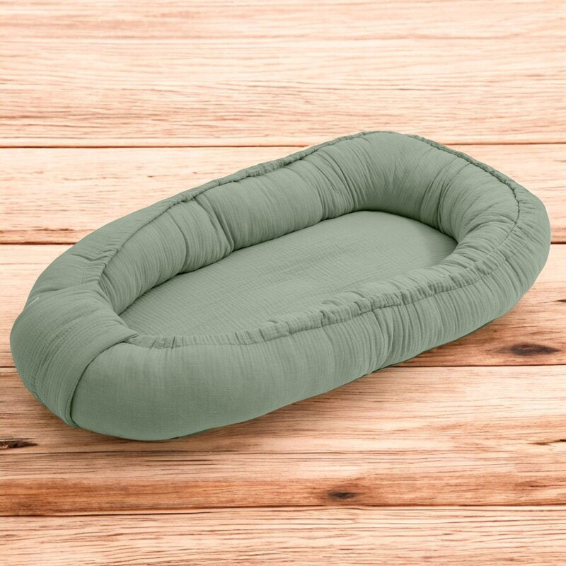 Baby nest New Baby Muselina 80x50 cm, Salvie – vedere pe fundal din lemn