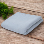 Păturică New Baby din muselină 70x100 cm gri – păturica pe o suprafață de lemn