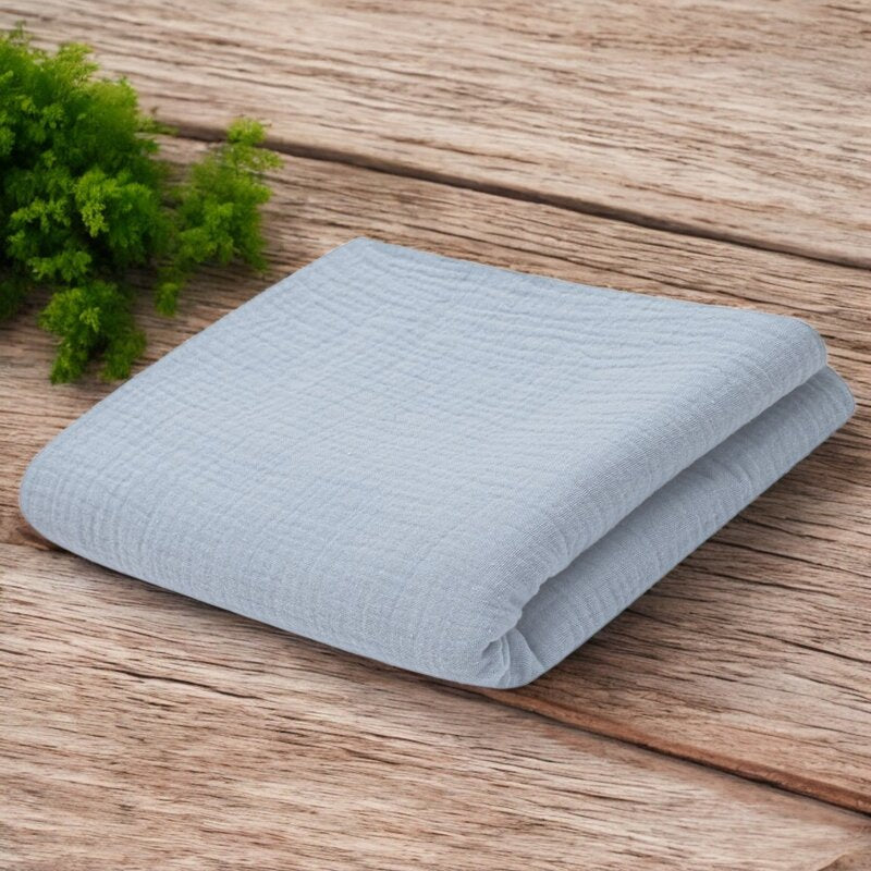 Păturică New Baby din muselină 70x100 cm gri – păturica pe o suprafață de lemn
