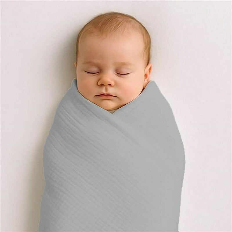 Păturică New Baby din muselină 70x100 cm gri – bebeluș învelit în păturică