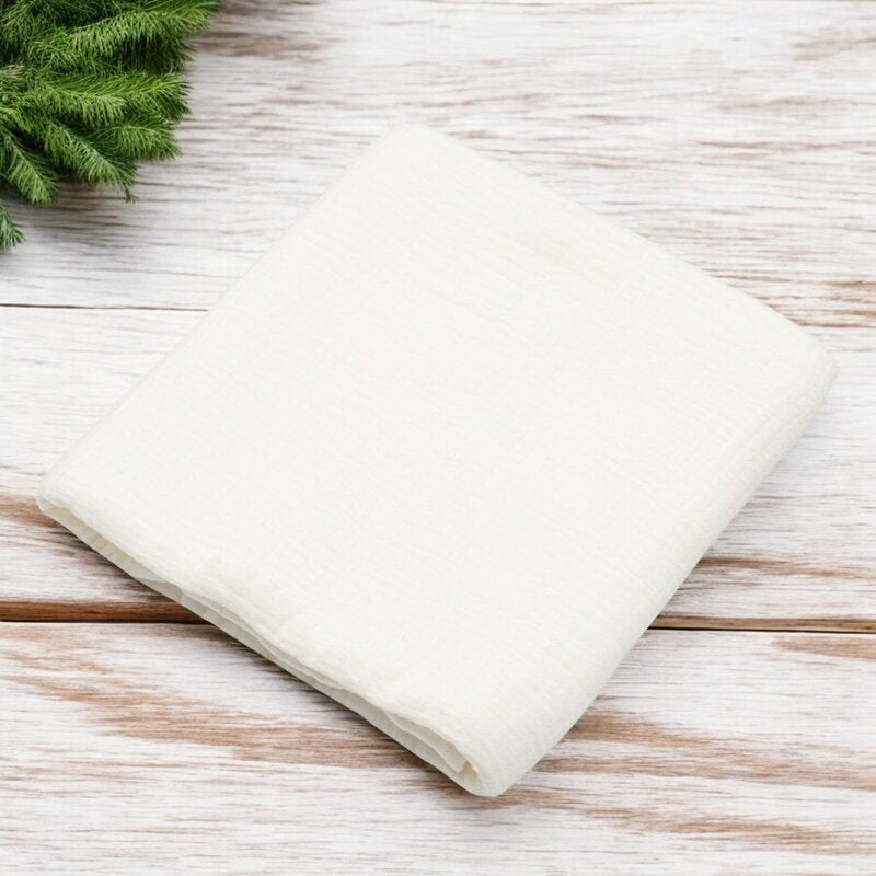 Păturică New Baby Soft Muslin alb – păturica așezată pe lemn