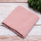 Păturică New Baby Soft Muslin roz – păturica așezată pe lemn