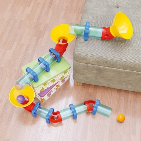 Pista cu bile Quercetti Migoga Pipe – traseu din tuburi construit lângă o canapea