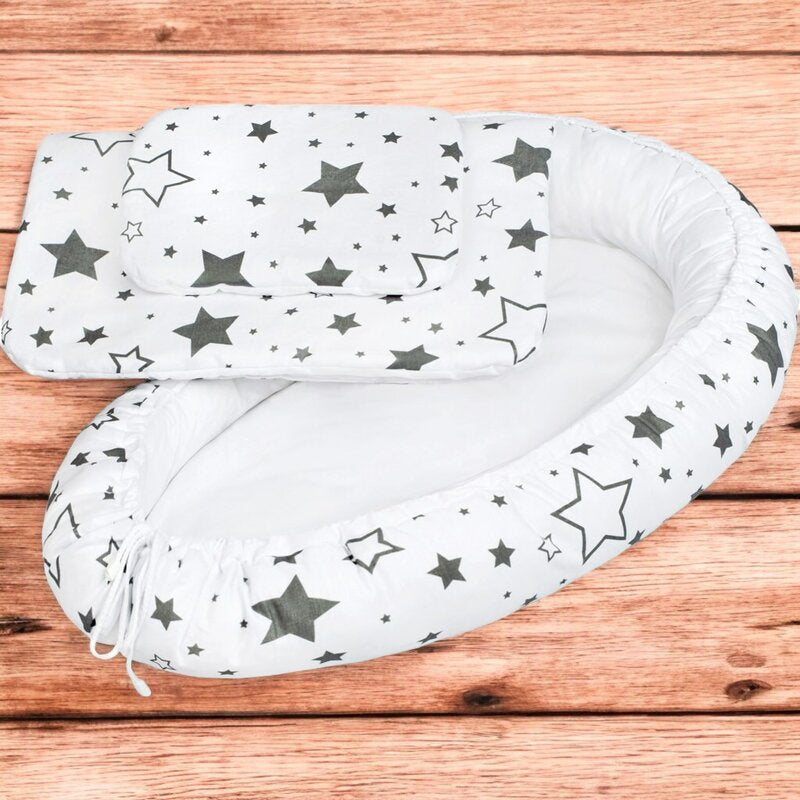 Baby nest New Baby Stars 78x48 cm, Alb cu stele gri – prezentare pe fundal din lemn