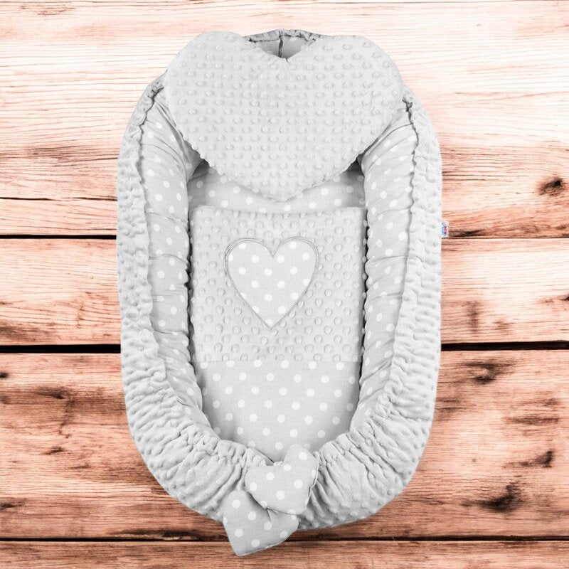 Baby nest New Baby Luxury Minky Heart 75x55 cm, Gri – prezentare pe fundal din lemn